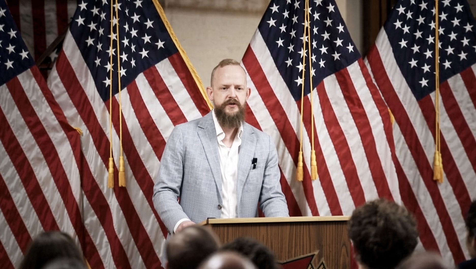 A speaker addressing a room from a podium
